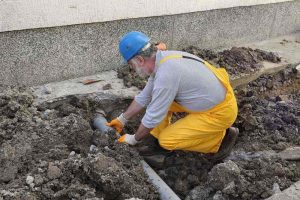 plumber fixing sewer pipe